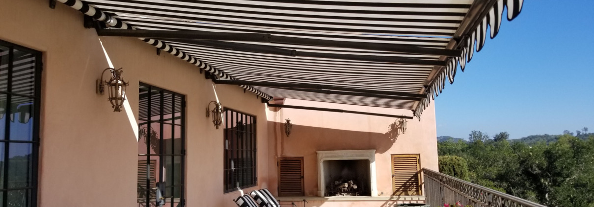 Black and white striped retractable awning covering patio in Montecito