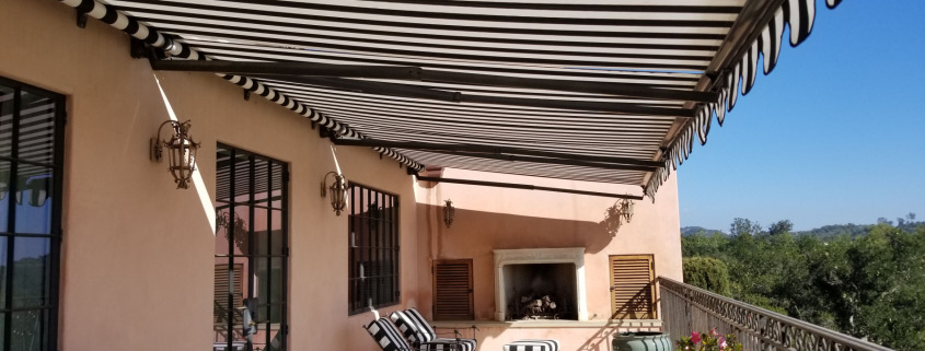 Black and white striped retractable awning covering patio in Montecito
